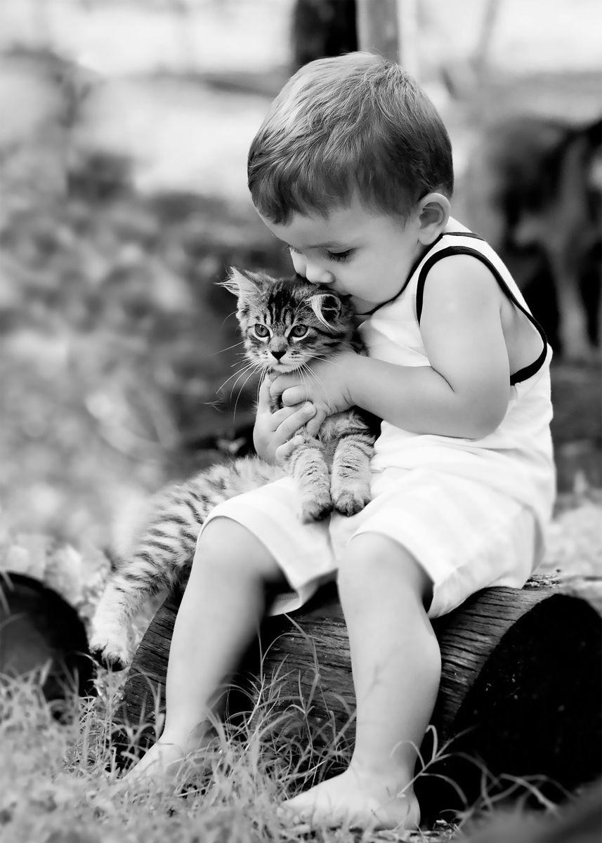 Foto en blanco y negro de un niño abrazando un gatito