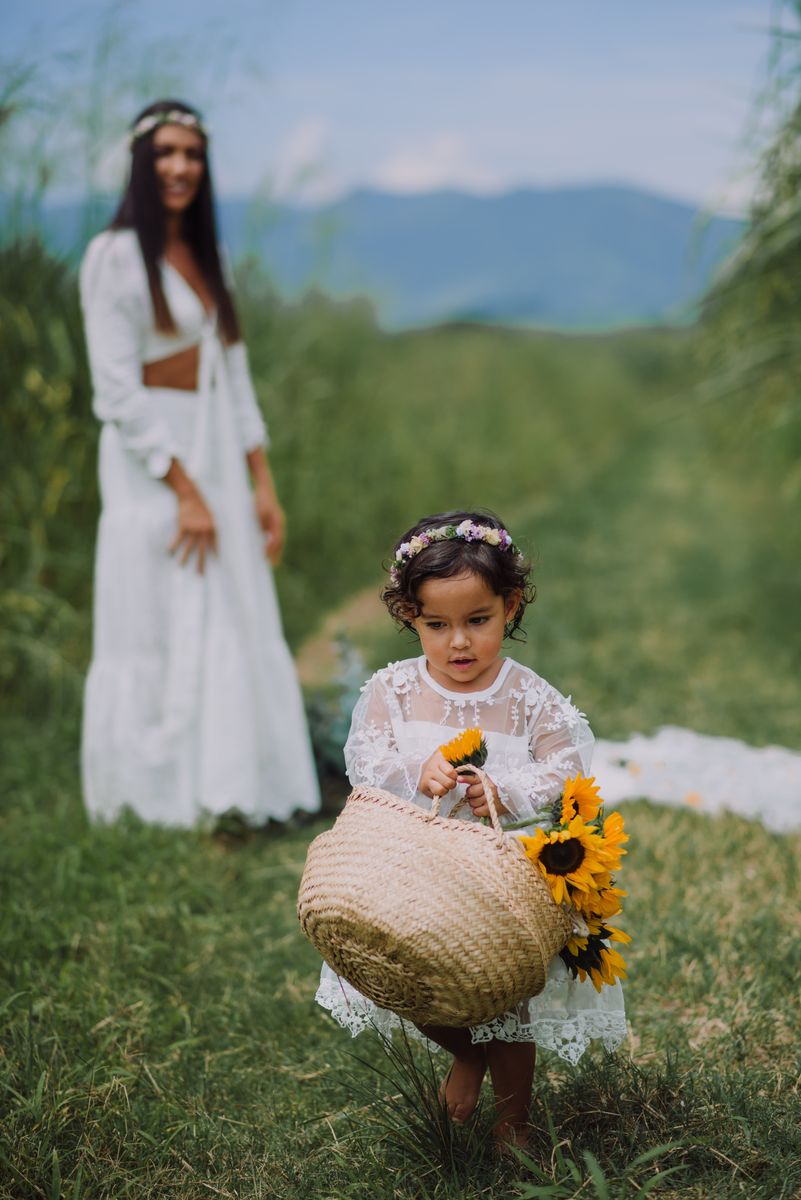 Mamá e hija con girasoles en un campo verde